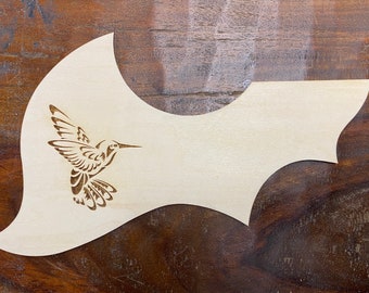 May include: A wooden guitar pick with a laser-etched hummingbird design.