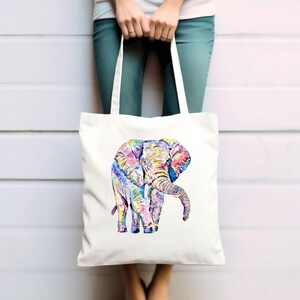 May include: A white tote bag with a colorful illustration of an elephant. The elephant is painted in shades of pink, blue, yellow, and green.