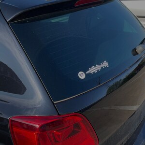 May include: A black car with a rear window sticker featuring a white Spotify logo and a white barcode-like design.