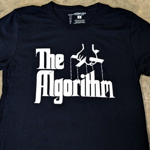 May include: Black t-shirt with a white graphic of a hand controlling strings attached to the word "The Algorithm".