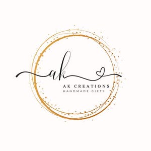May include: A logo featuring the handwritten letters "ak" in black script, encircled by a gold-colored ring with a dotted texture. The text "AK CREATIONS HANDMADE GIFTS" is below the letters.