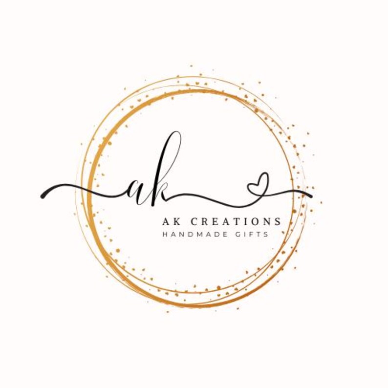 May include: A logo featuring the handwritten letters "ak" in black script, encircled by a gold-colored ring with a dotted texture. The text "AK CREATIONS HANDMADE GIFTS" is below the letters.