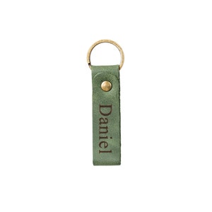 May include: Green leather keychain with a brass ring and the name "Daniel" engraved on it.