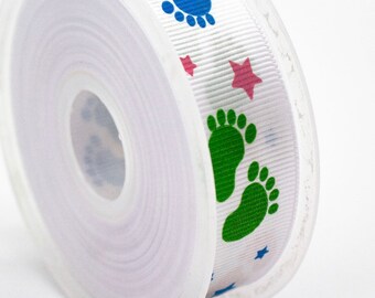 May include: A roll of white ribbon featuring a repeating pattern of blue and green footprints, pink stars, and blue stars. The ribbon is on a clear plastic spool, ideal for baby-themed crafts or gifts.