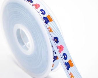 May include: A spool of pale blue ribbon featuring a repeating pattern of colourful floral and geometric designs. The ribbon is made of a smooth material, suitable for crafts, gift wrapping, or embellishments.