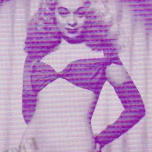 Könnte beinhalten: Ein Vintage-Bild einer Person in einem zweiteiligen lila Outfit. Das Oberteil ist ein geknotetes Bandeau, und die langen Ärmel sind am Oberteil befestigt. Der Unterteil ist ein hoch taillierter Slip. Das Bild hat eine Retro-Ästhetik.