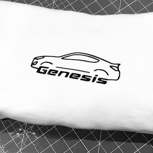May include: White t-shirt with a black outline of a car and the word "Genesis" printed on it.