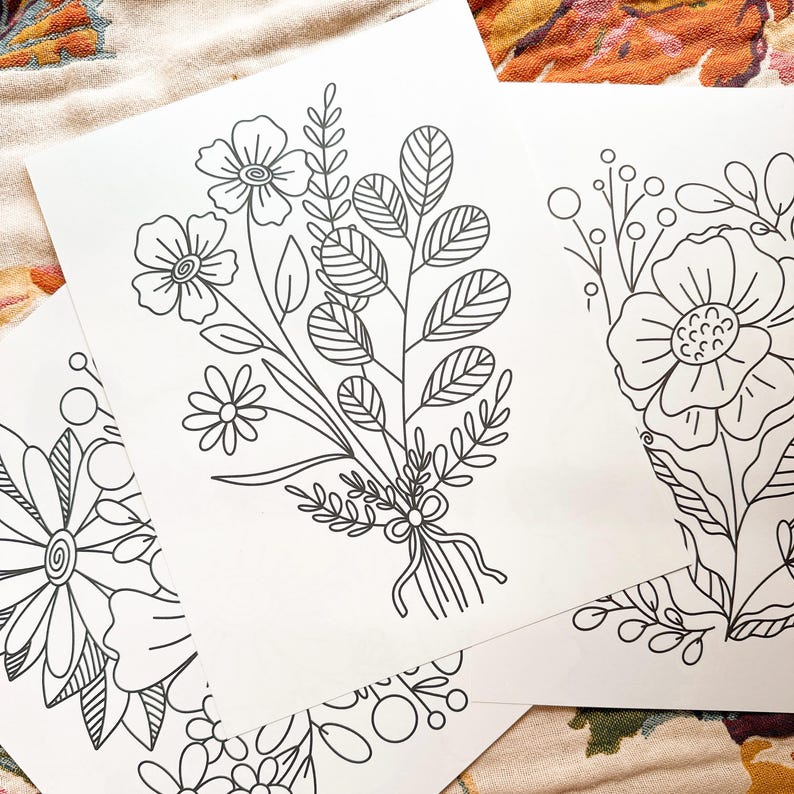May include: Three black and white line drawings of floral bouquets. The bouquets are made up of various flowers and leaves. The drawings are on white paper.
