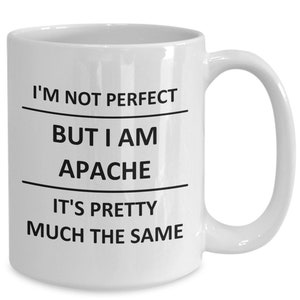 May include: White ceramic coffee mug with black text that reads "I'm not perfect but I am Apache it's pretty much the same."