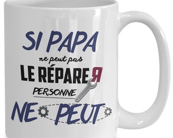May include: White ceramic mug with a blue and black design that says "Si Papa ne peut pas le repare personne ne peut".