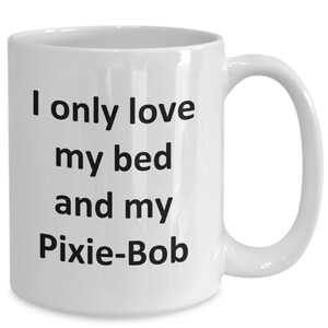 May include: White ceramic coffee mug with black text that reads "I only love my bed and my Pixie-Bob".