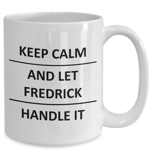 May include: White ceramic coffee mug with black text that reads "Keep Calm and Let Fredrick Handle It".