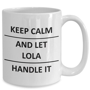 May include: White ceramic coffee mug with black text that reads "Keep Calm and Let Lola Handle It."
