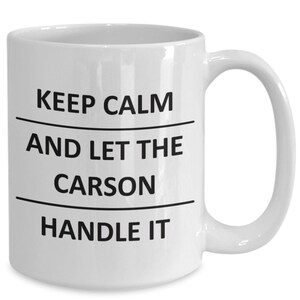 May include: White ceramic coffee mug with black text that reads "Keep Calm and Let the Carson Handle It."