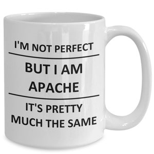 May include: White ceramic coffee mug with black text that reads "I'm not perfect but I am Apache it's pretty much the same".