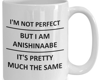 May include: White ceramic coffee mug with black text that reads "I'm not perfect but I am Anishinaabe it's pretty much the same."