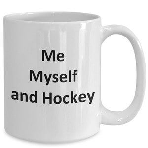 May include: White ceramic coffee mug with black text that reads "Me Myself and Hockey".