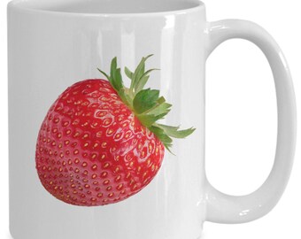 May include: White ceramic mug with a red strawberry illustration. The strawberry is in focus and has a green stem and leaves.