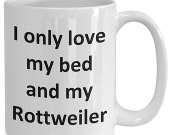 May include: White ceramic coffee mug with black text that reads "I only love my bed and my Rottweiler".