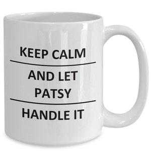 May include: White ceramic coffee mug with black text that reads "Keep Calm and Let Patsy Handle It".