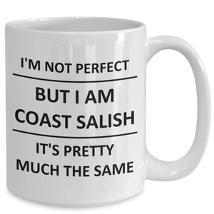 Peut inclure: Une tasse à café en céramique blanche avec du texte noir qui dit "Je ne suis pas parfait mais je suis Coast Salish c'est à peu près la même chose."