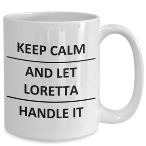 May include: White ceramic coffee mug with black text that reads "Keep Calm and Let Loretta Handle It".