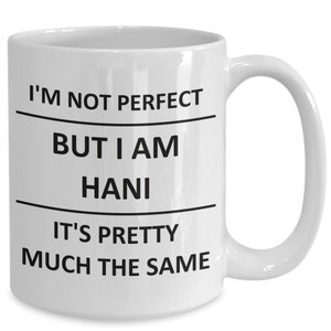May include: White ceramic coffee mug with black text that reads "I'm not perfect but I am Hani it's pretty much the same".