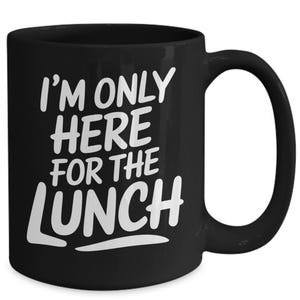 May include: Black coffee mug with white text that reads "I'm only here for the lunch".