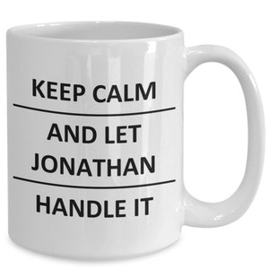 May include: White ceramic coffee mug with black text that reads "Keep Calm and Let Jonathan Handle It".