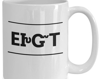 May include: White ceramic coffee mug with black text that reads "Eh G'T" in a bold font.