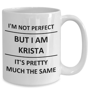 May include: White ceramic coffee mug with black text that reads "I'm not perfect but I am Krista it's pretty much the same."