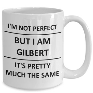 May include: White ceramic coffee mug with black text that reads "I'm not perfect but I am Gilbert it's pretty much the same."