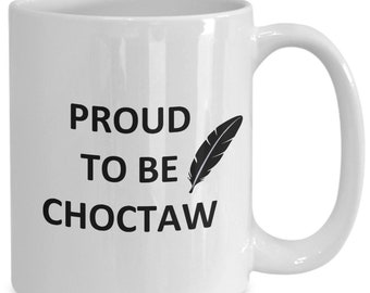 May include: White ceramic coffee mug with black text that reads "Proud to be Choctaw" and a black feather graphic.