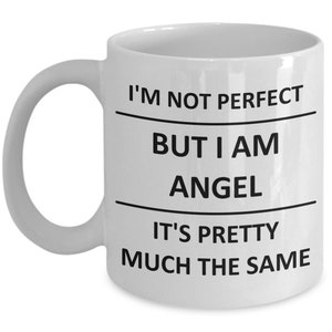 May include: White ceramic coffee mug with black text that reads "I'm not perfect but I am angel it's pretty much the same".