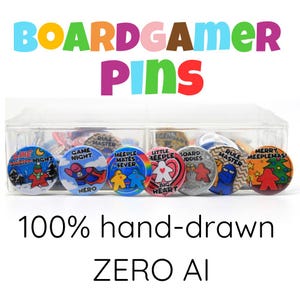 May include: A selection of colourful round pins in a clear plastic container. The pins display game-related designs and text, including "BOARDGAMER PINS", "GAME NIGHT", and "HERO". The text "100% hand-drawn ZERO AI" is also visible.