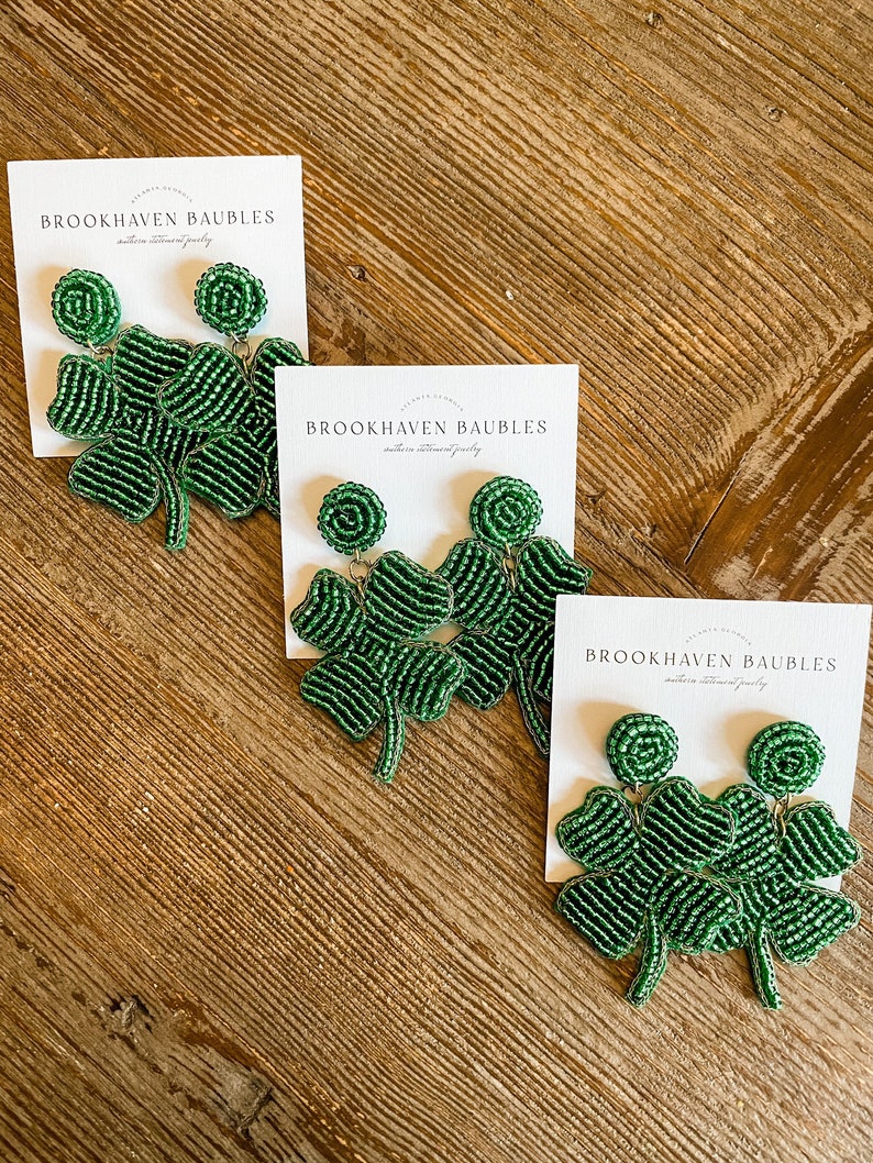 May include: Three pairs of green beaded shamrock earrings on white cards with the text "Brookhaven Baubles" on each card.
