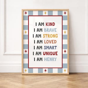 Może przedstawiać: Oprawiony wydruk z napisem "I AM KIND, BRAVE, STRONG, LOVED, SMART, UNIQUE, I AM HENRY" w kolorowym tekście. Wydruk ma jasną drewnianą ramę, czerwoną obwódkę i niebiesko-biały wzór w kratkę. Ozdobne gwiazdki umieszczono wokół ramy.
