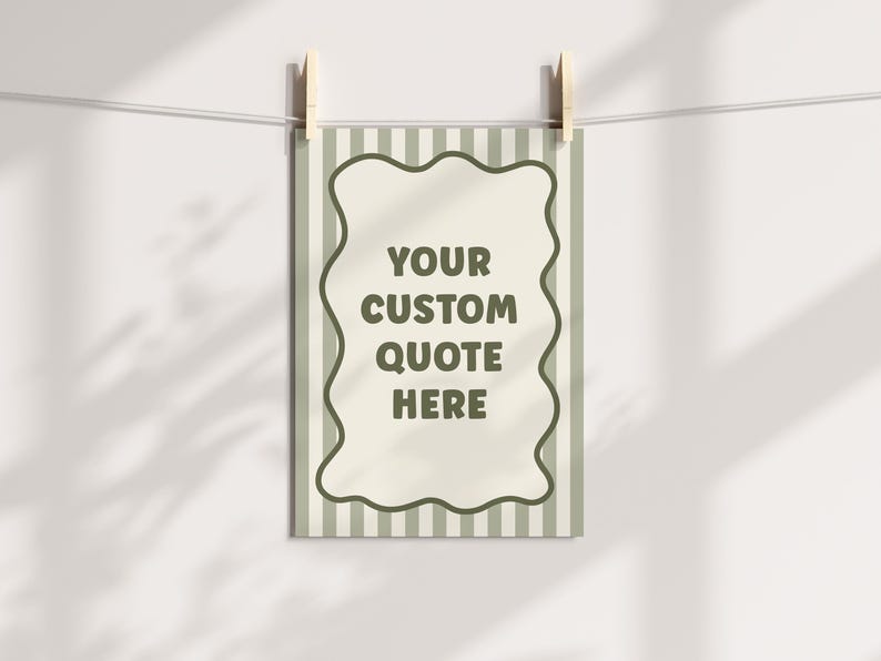 May include: A rectangular print with a wavy border and striped background is suspended by wooden clothespins. The print features the text "YOUR CUSTOM QUOTE HERE" in a dark green color, perfect for personalized decor.