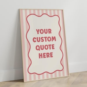 May include: A framed poster with a light wood frame. The poster features a cream-colored background with pink vertical stripes. A wavy-edged shape in the center contains the text "YOUR CUSTOM QUOTE HERE" in a dark pink color.