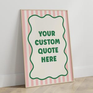 May include: A framed poster with a light wood frame. The background has pink and white vertical stripes. A cream-colored shape with a green border in the center contains the text "YOUR CUSTOM QUOTE HERE" in green.
