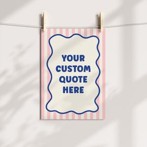 May include: A rectangular print with a pink and white striped background is held by wooden clothespins. The print features a cream-colored center with a blue wavy border and the text "YOUR CUSTOM QUOTE HERE".