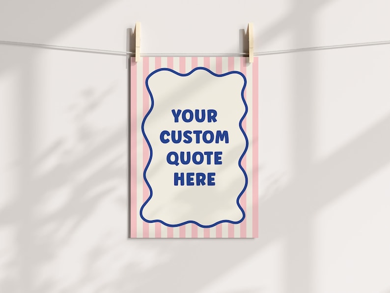 May include: A rectangular print with a pink and white striped background is held by wooden clothespins. The print features a cream-colored center with a blue wavy border and the text "YOUR CUSTOM QUOTE HERE".