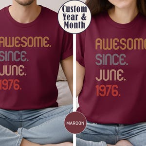 May include: Maroon t-shirts with the text "AWESOME. SINCE. JUNE. 1976." in retro-style lettering. The shirts have a crew neck and short sleeves. The image also includes a circular graphic that says "Custom Year & Month."