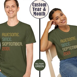 Op de afbeelding: Een militair groen t-shirt met korte mouwen en de tekst "AWESOME. SINCE. SEPTEMBER. 2001." gedrukt in een gestapeld, meerkleurig retro lettertype. Het ontwerp bevat een cirkelvormige badge met "Custom Year & Month" en een "MILITARY GREEN" kleurlabel.