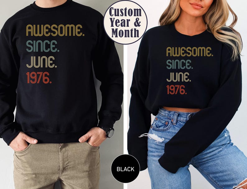 May include: Black sweatshirt with the text "AWESOME. SINCE. JUNE. 1976." in retro-style lettering. The sweatshirt is worn by a person. The image also includes a black circle with the word "BLACK" and a white circle with the words "Custom Year & Month."