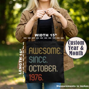 May include: A black tote bag featuring the text "AWESOME. SINCE. OCTOBER. 1976." in retro-style, multi-colored lettering. The bag measures 15 inches in width and 16 inches in length. A circular graphic on the right reads "Custom Year & Month."