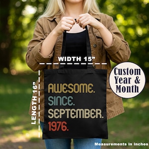 May include: A black tote bag with the text AWESOME. SINCE. SEPTEMBER. 1976. printed in retro-style yellow, teal, and orange lettering. The bag features a width of 15 inches and a length of 16 inches, with a circular graphic indicating custom year and month.