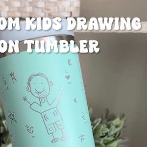 May include: A light teal tumbler with a custom drawing of a person, hearts, and stars. The text "CUSTOM KIDS DRAWING ON TUMBLER" is at the top. A smaller drawing is shown below the tumbler.