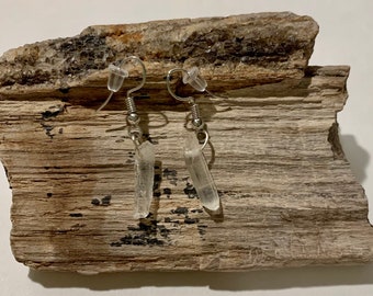 May include: A pair of silver dangle earrings with clear crystal teardrop shaped stones.