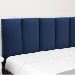 Könnte beinhalten: Ein marineblaues, gepolstertes Kopfteil mit vertikalem Paneeldesign. Das Kopfteil befindet sich über einem Bett mit weißer Bettwäsche. Das Kopfteil ist einfarbig und verleiht dem Schlafzimmer eine moderne Note.